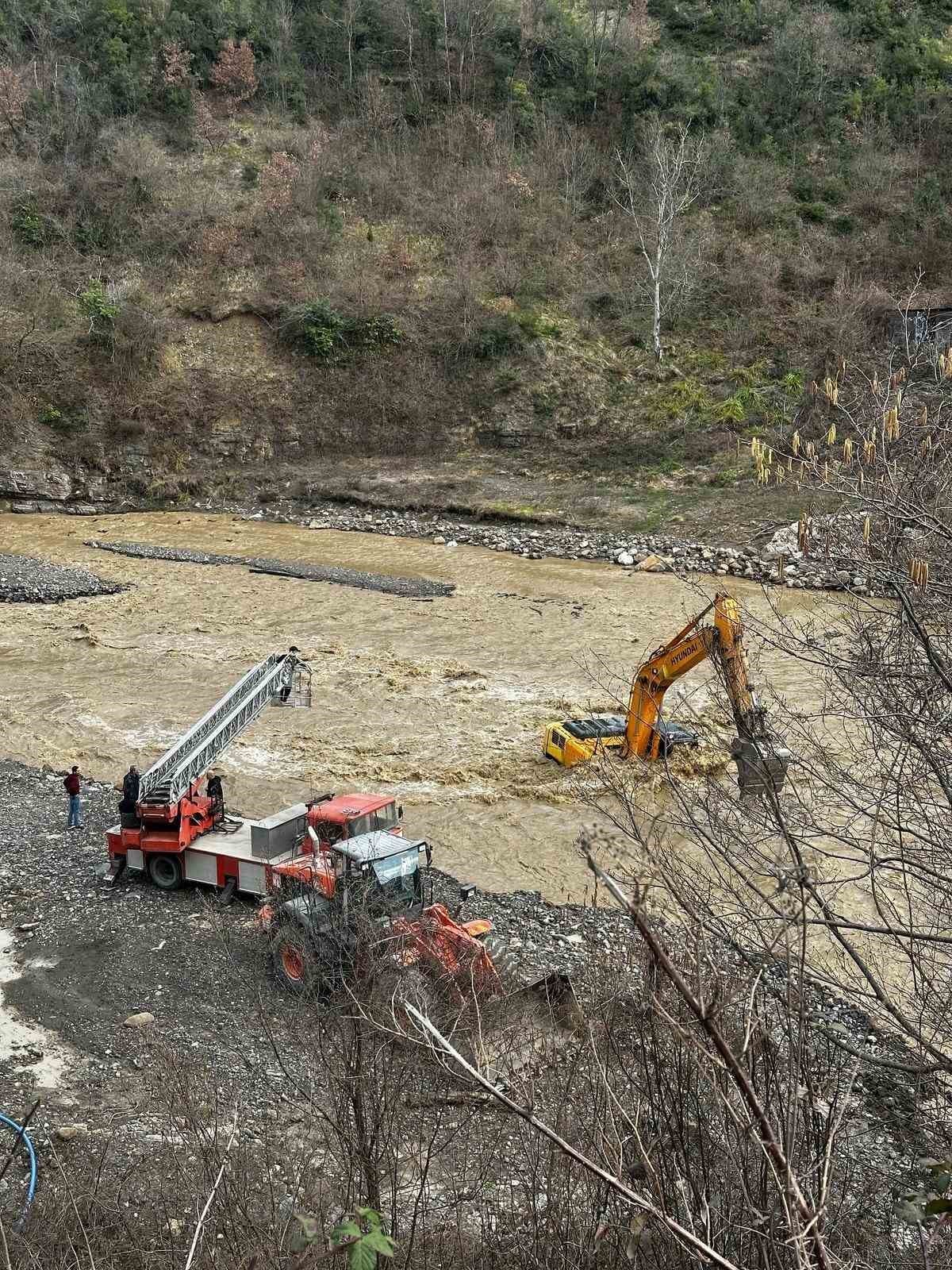 Çayın debisi yükselince iş makinesinin üzerinde mahsur kaldı